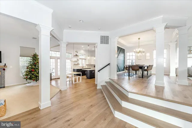 a dining room with furniture a chandelier and wooden floor