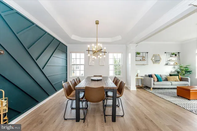 a dining room with furniture a chandelier and wooden floor
