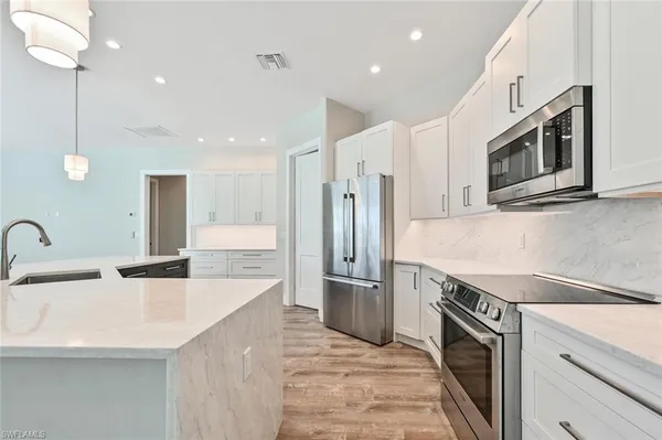 a kitchen with stainless steel appliances granite countertop a sink and a refrigerator