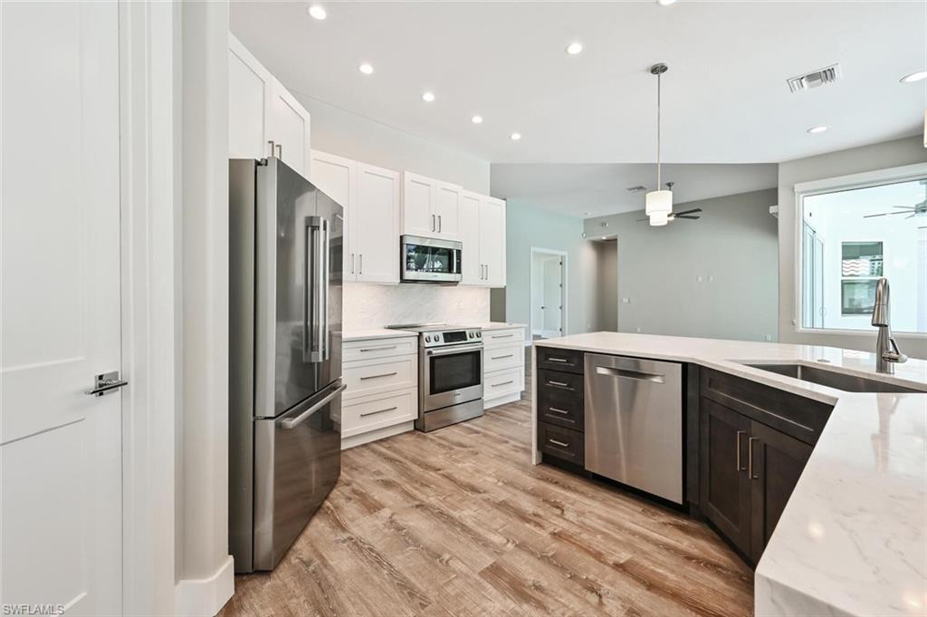 4231 Crayton Road Naples, FL 34103 - Photo 13 of 46 a modern kitchen with stainless steel appliances a refrigerator and a sink