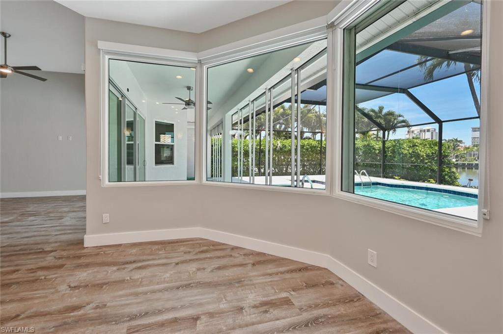4231 Crayton Road Naples, FL 34103 - Photo 16 of 46 a view of an empty room with wooden floor and a window