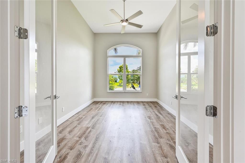 4231 Crayton Road Naples, FL 34103 - Photo 17 of 46 wooden floor in an empty room with a window