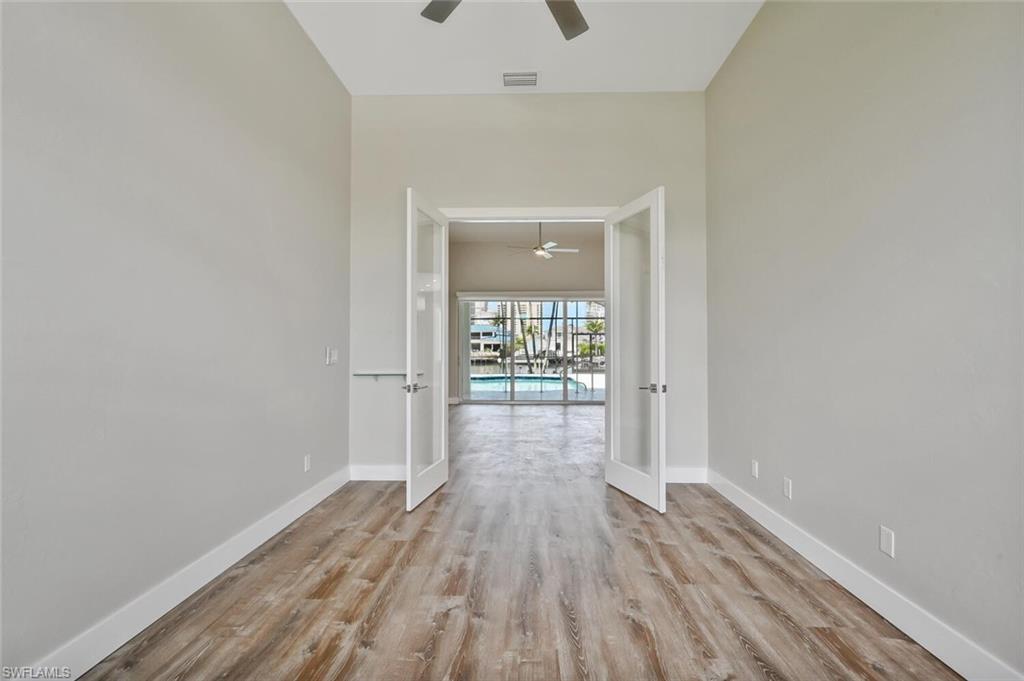 4231 Crayton Road Naples, FL 34103 - Photo 18 of 46 an empty room with wooden floor and windows