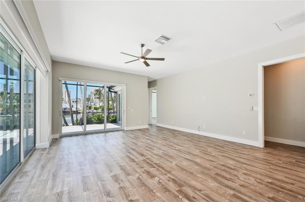 4231 Crayton Road Naples, FL 34103 - Photo 19 of 46 a view of an empty room with a window and wooden floor