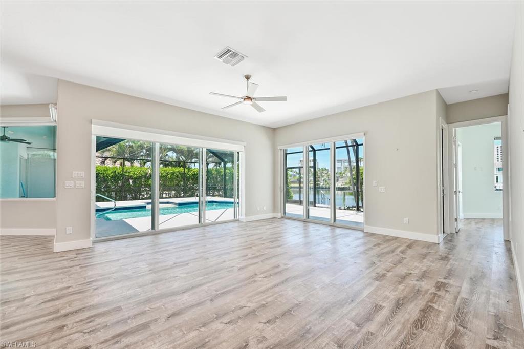 4231 Crayton Road Naples, FL 34103 - Photo 20 of 46 a view of an empty room with wooden floor and a window
