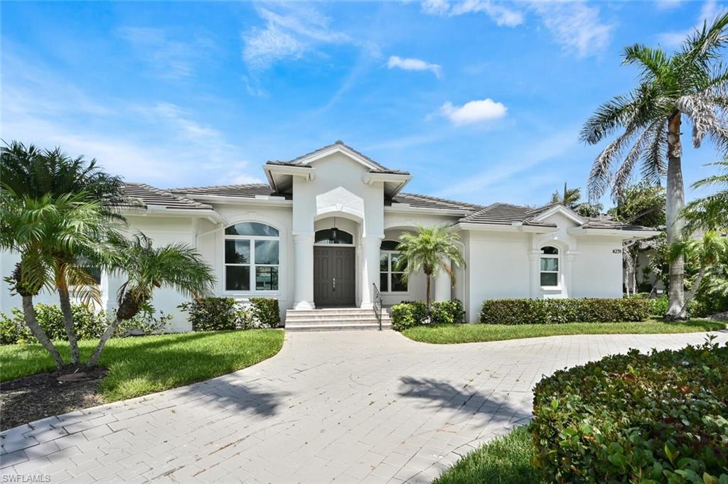 4231 Crayton Road Naples, FL 34103 - Photo 2 of 46 a front view of a house with a garden