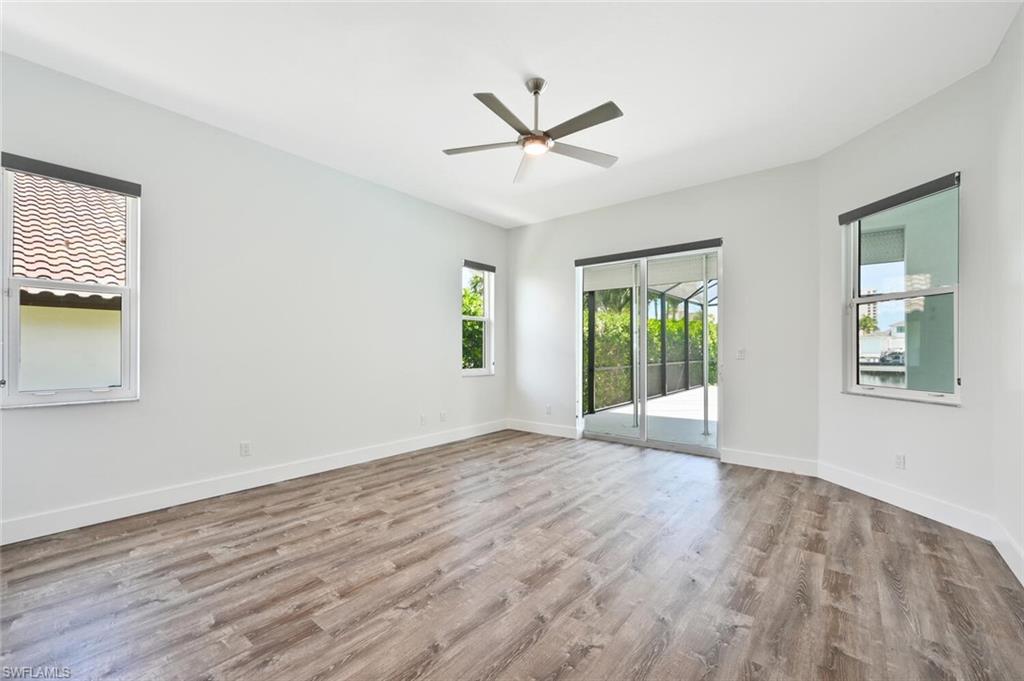 4231 Crayton Road Naples, FL 34103 - Photo 22 of 46 a view of an empty room with wooden floor and a window