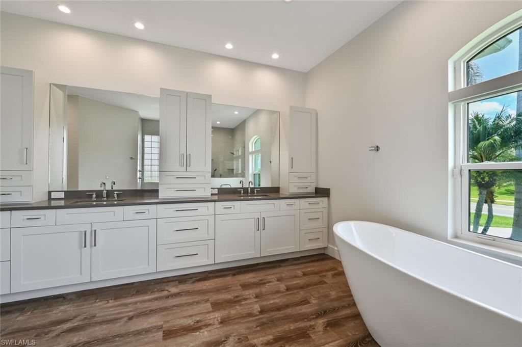4231 Crayton Road Naples, FL 34103 - Photo 27 of 46 a bathroom with a granite countertop sink and a large mirror