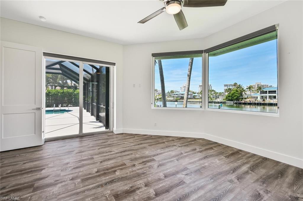 4231 Crayton Road Naples, FL 34103 - Photo 29 of 46 a view of an empty room with wooden floor and a window