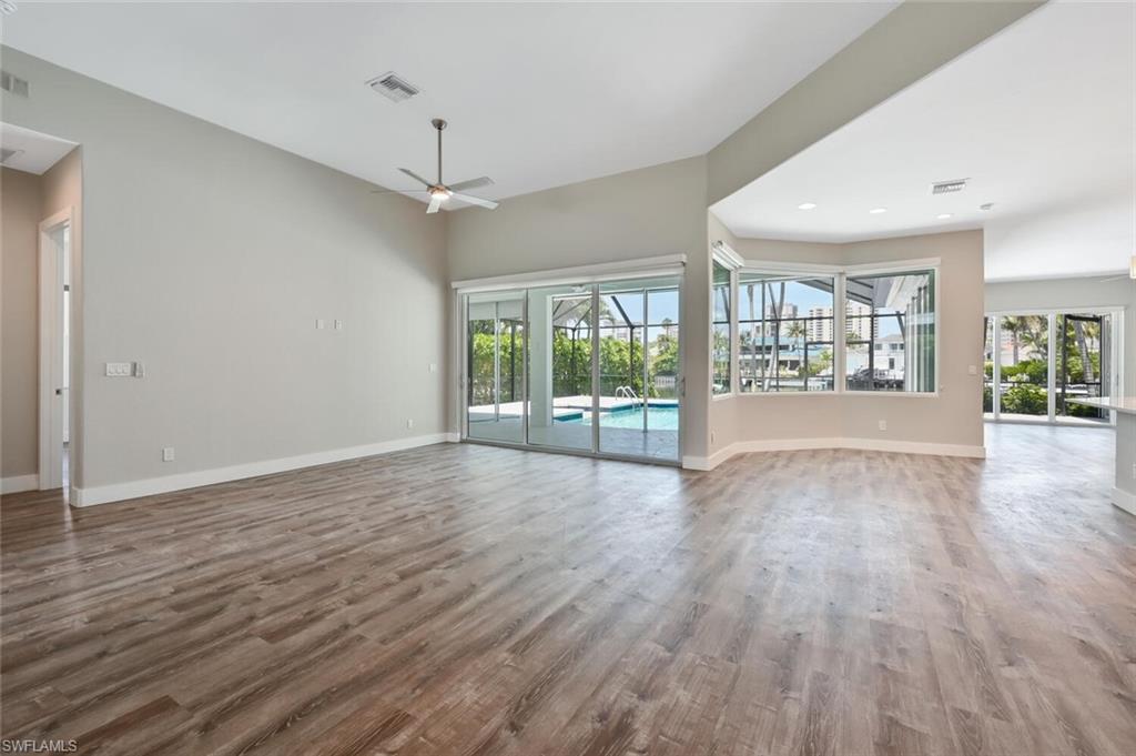 4231 Crayton Road Naples, FL 34103 - Photo 3 of 46 a view of an empty room with wooden floor and a window