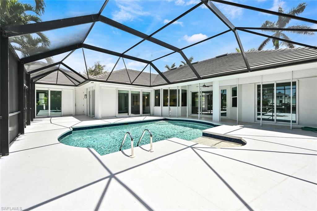 4231 Crayton Road Naples, FL 34103 - Photo 39 of 46 a view of a house with a patio and a yard