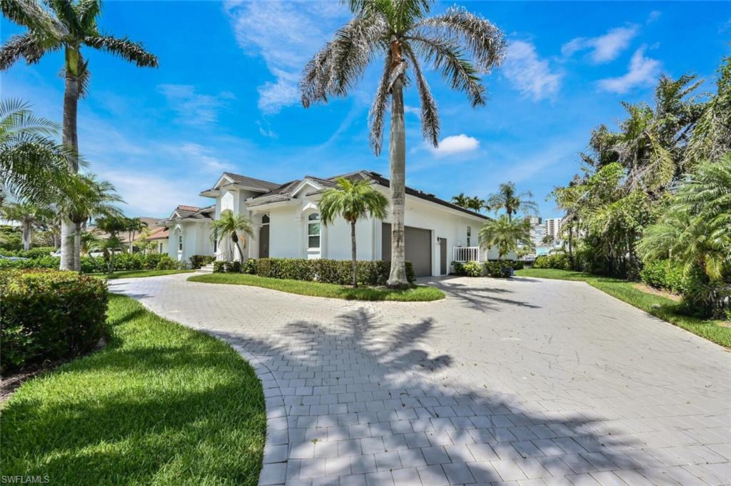 4231 Crayton Road Naples, FL 34103 - Photo 46 of 46 a front view of a house with a yard and palm trees