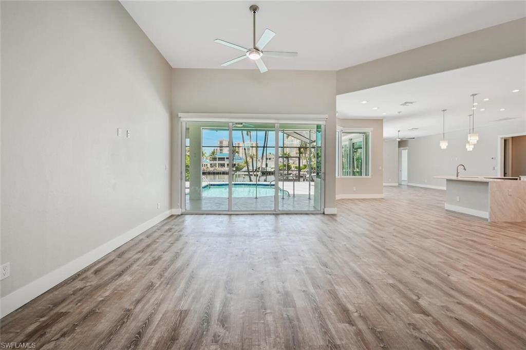 4231 Crayton Road Naples, FL 34103 - Photo 5 of 46 wooden floor in an empty room with a window