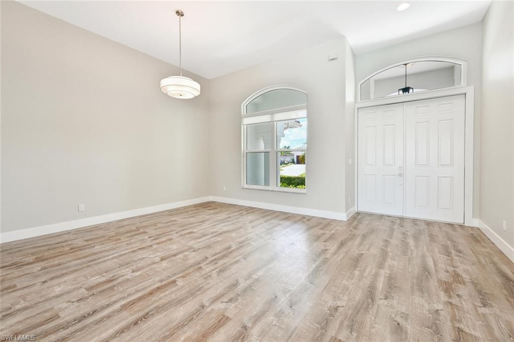 4231 Crayton Road Naples, FL 34103 - Photo 7 of 46 an empty room with wooden floor and windows