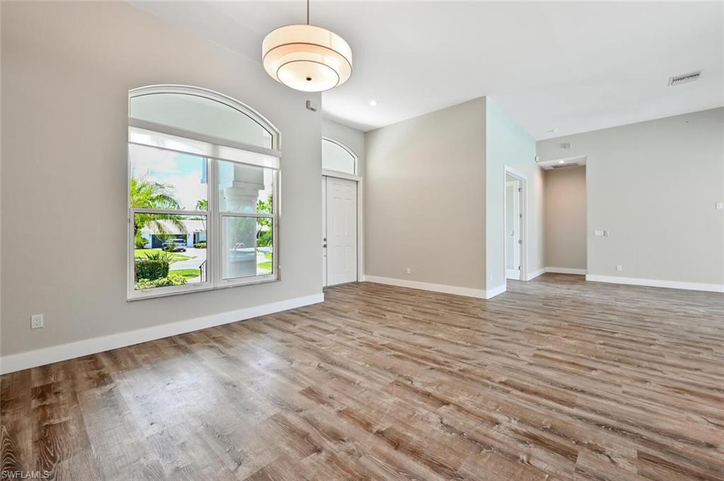 4231 Crayton Road Naples, FL 34103 - Photo 8 of 46 an empty room with wooden floor and windows