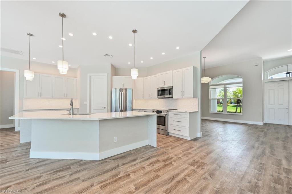 4231 Crayton Road Naples, FL 34103 - Photo 10 of 46 a large kitchen with kitchen island a sink table and chairs