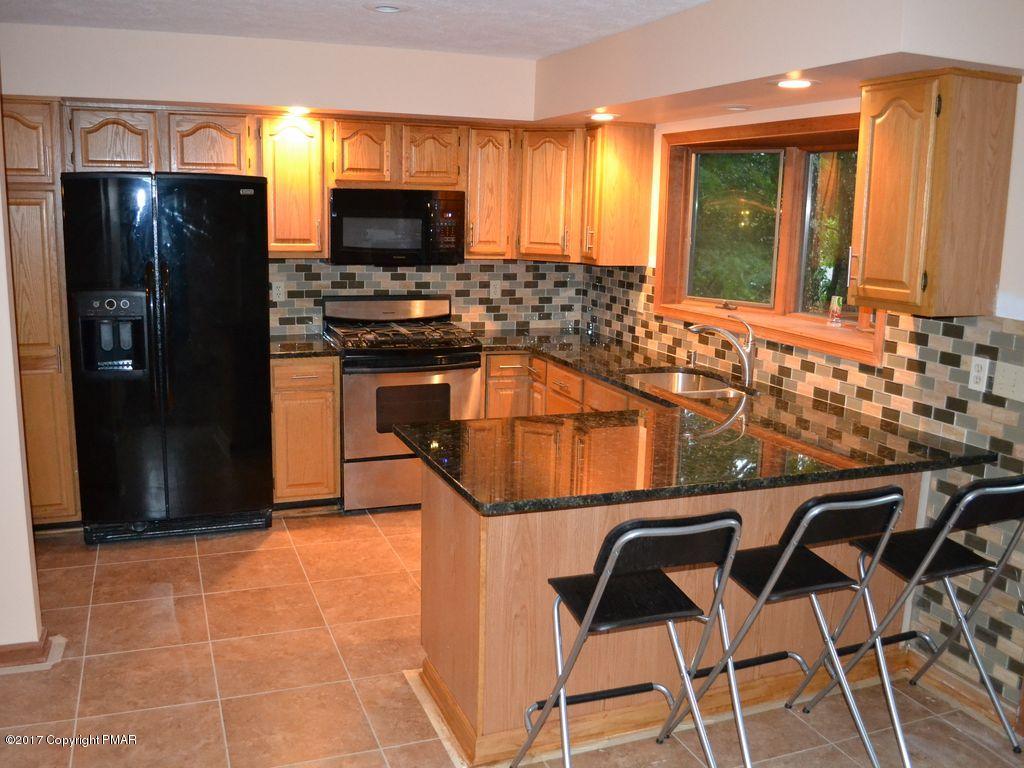 1044 Upper Ridge View Drive East Stroudsburg, PA 18302 - Photo 5 of 27 a kitchen with a sink a refrigerator and chairs