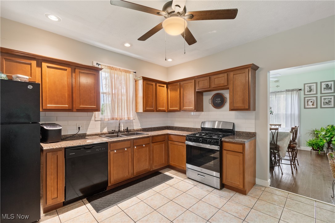3609 Mahoning Road Northeast Canton, OH 44705 - Photo 8 of 31 Kitchen featuring brown cabinets, black appliances, backsplash, light tile patterned floors, and recessed lighting