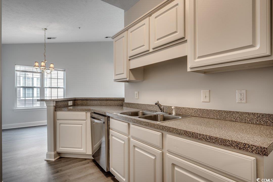 999 Algonquin Drive, Unit E Pawleys Island, SC 29585 - Photo 11 of 37 Kitchen featuring a peninsula, dark wood-type flooring, a sink, dishwasher, and decorative light fixtures