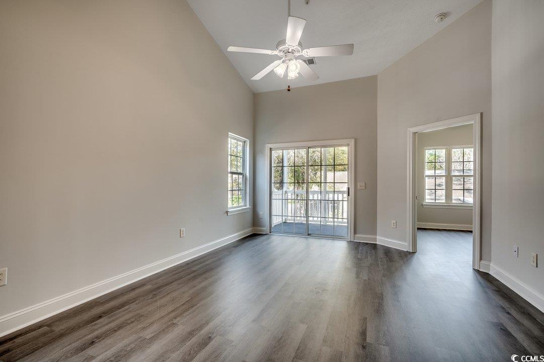999 Algonquin Drive, Unit E Pawleys Island, SC 29585 - Photo 19 of 37 Unfurnished room with high vaulted ceiling, baseboards, and dark wood finished floors