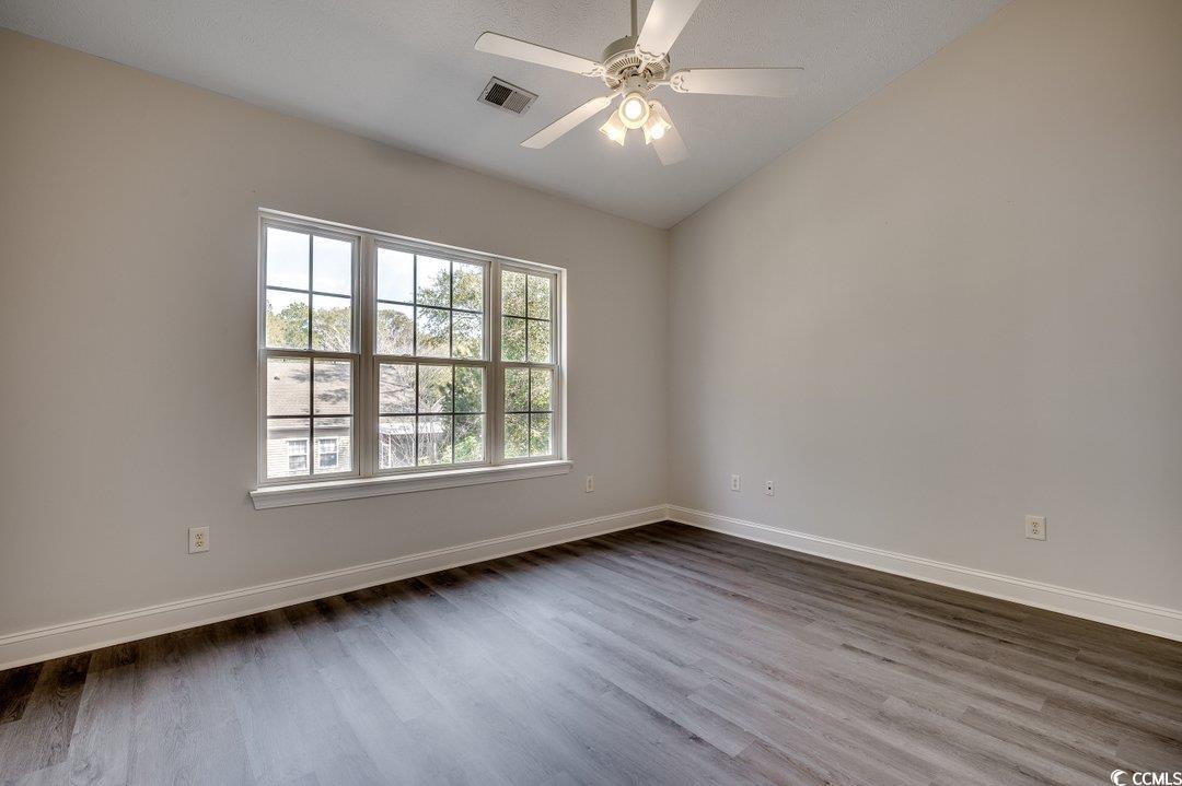 999 Algonquin Drive, Unit E Pawleys Island, SC 29585 - Photo 20 of 37 Empty room featuring dark wood-type flooring, a ceiling fan, visible vents, and baseboards