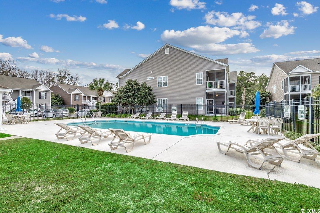 999 Algonquin Drive, Unit E Pawleys Island, SC 29585 - Photo 26 of 37 Community pool featuring a residential view, a patio area, a yard, and fence