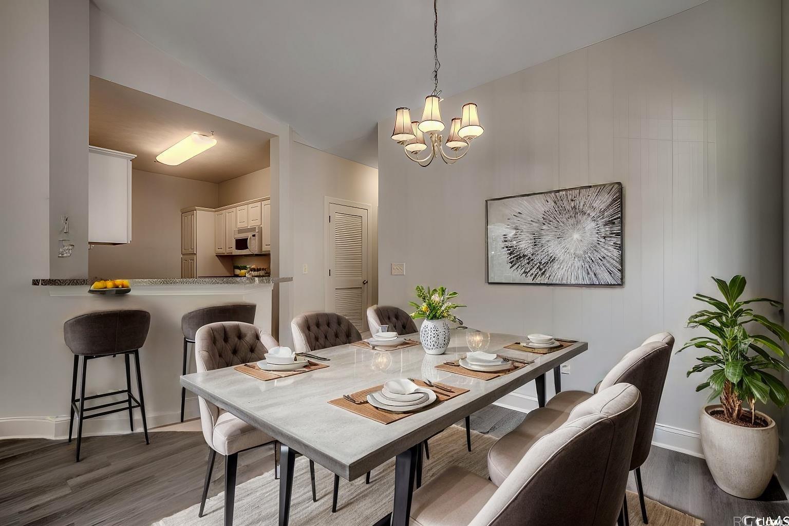 999 Algonquin Drive, Unit E Pawleys Island, SC 29585 - Photo 3 of 37 Dining area featuring baseboards, a notable chandelier, wood finished floors, and lofted ceiling