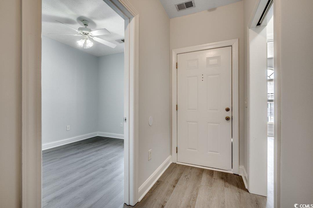 999 Algonquin Drive, Unit E Pawleys Island, SC 29585 - Photo 8 of 37 Foyer entrance featuring ceiling fan, wood finished floors, visible vents, and baseboards