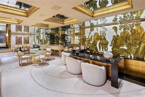 a living room with couches and kitchen view with wooden floor