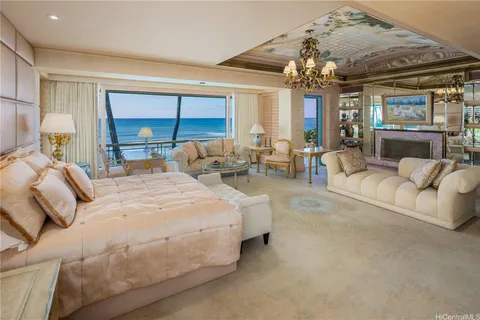 a large bedroom with bed and a chandelier