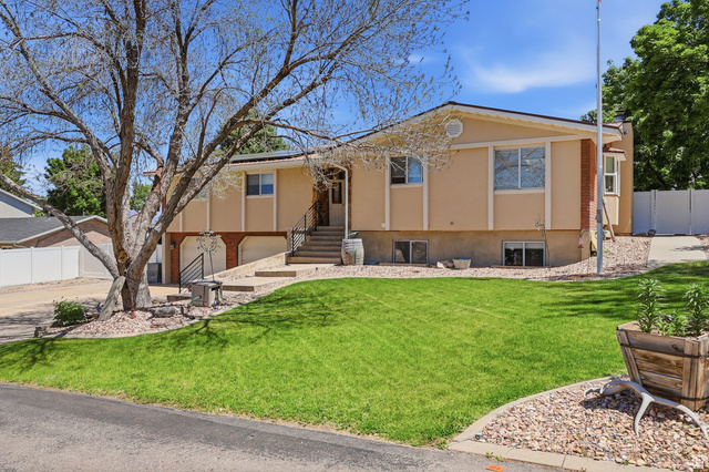 114 North Clark Lane Elk Ridge, UT 84651 - Photo 2 of 26 Split-level residence featuring a stucco exterior with brick accents and a prominent front lawn