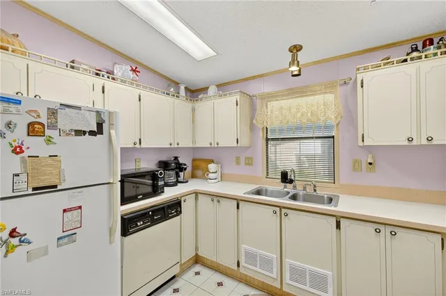 a kitchen with stainless steel appliances a sink a window and cabinets