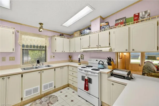 a kitchen with stainless steel appliances a sink a stove a refrigerator and cabinets