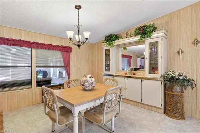 a dining room filled chandelier and kitchen view