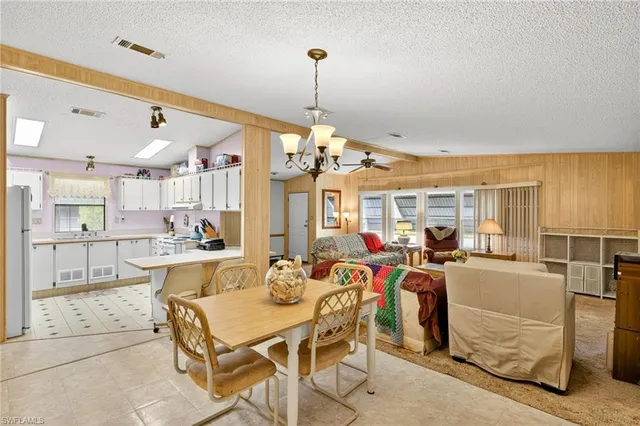 a view of a dining room and livingroom with furniture wooden floor a chandelier