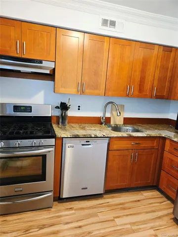 a kitchen with stainless steel appliances granite countertop a stove a sink and a microwave