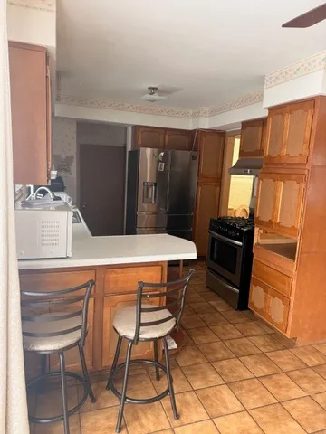 a kitchen with granite countertop a refrigerator stove top oven and sink
