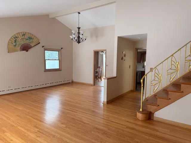 a view of a livingroom with wooden floor and staircase