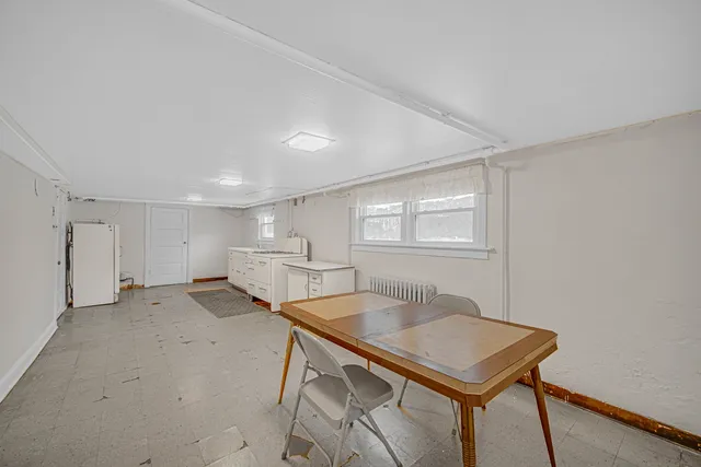 a kitchen with a table chairs refrigerator and cabinets