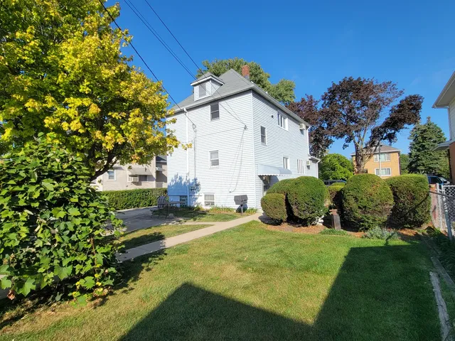 a view of a house with backyard and sitting area