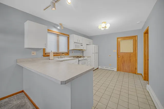 a kitchen with a sink a stove cabinets and a refrigerator