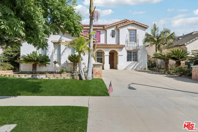 a front view of a house with a garden and plants