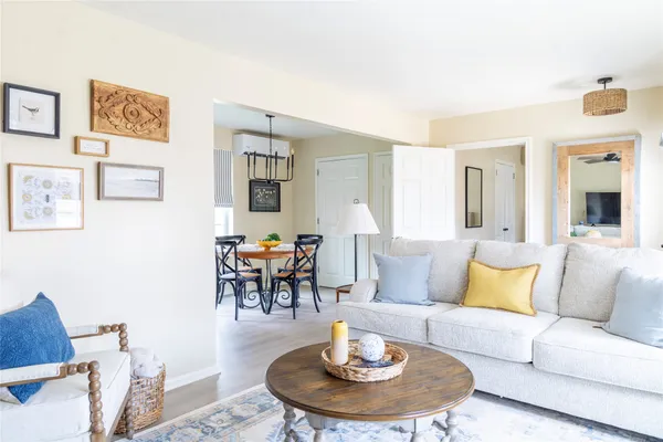 a living room with furniture and a dining table with garden view