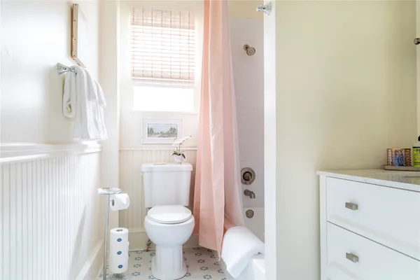 a bathroom with a toilet a sink and a window