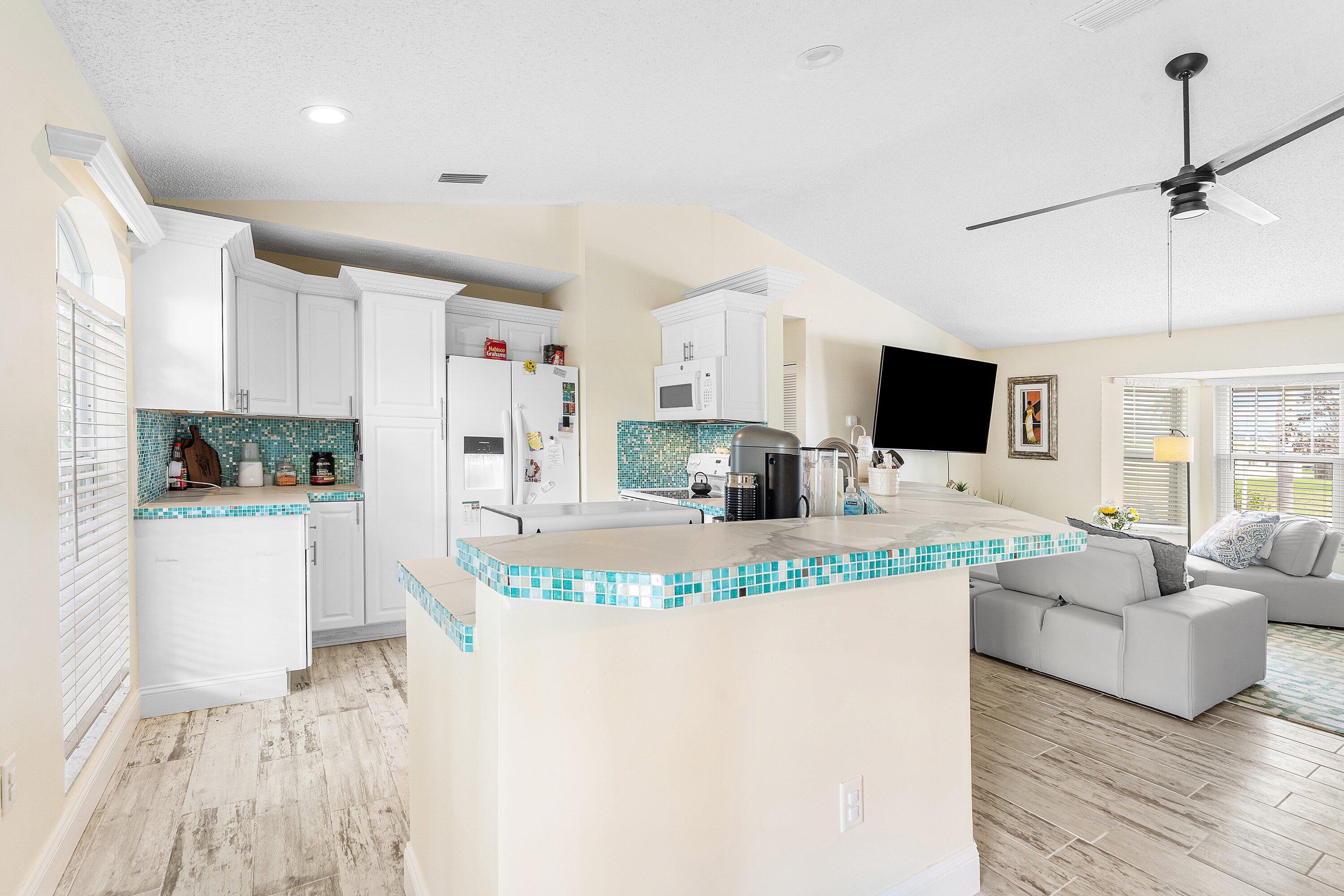 2114 Southeast Midtown Road Port St. Lucie, FL 34952 - Photo 11 of 41 a kitchen with kitchen island stainless steel appliances a stove sink microwave and cabinets
