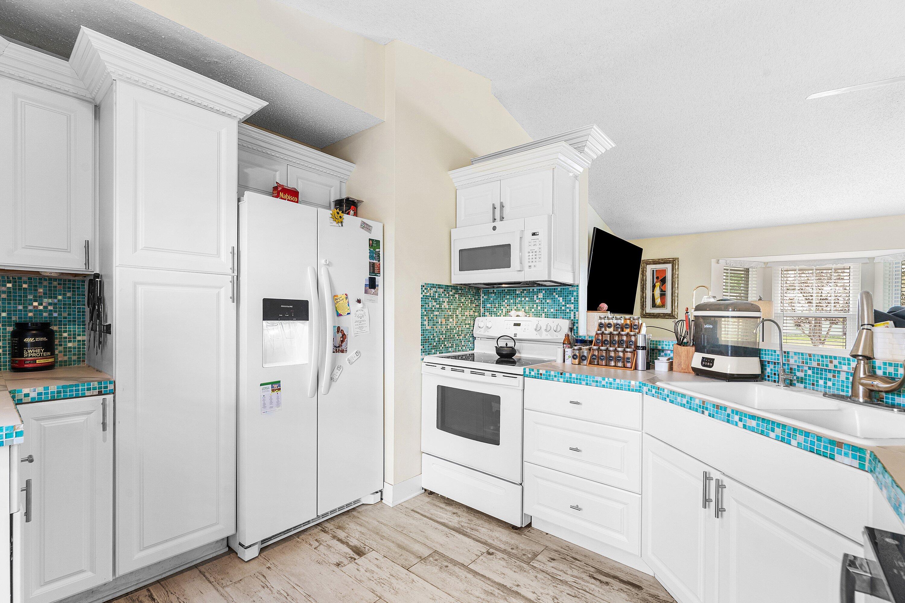 2114 Southeast Midtown Road Port St. Lucie, FL 34952 - Photo 12 of 41 a kitchen with white cabinets and white appliances