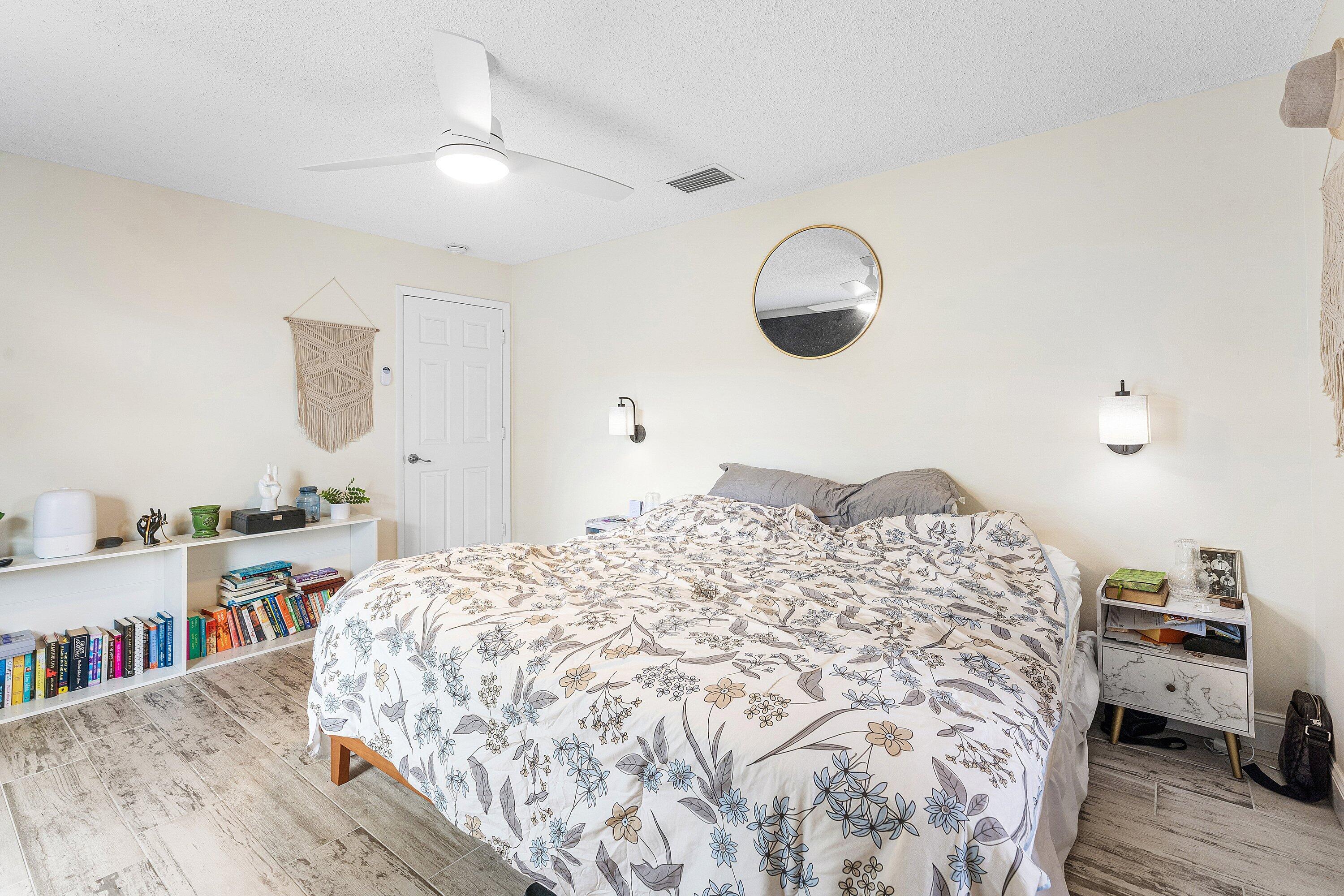 2114 Southeast Midtown Road Port St. Lucie, FL 34952 - Photo 16 of 41 a bedroom with a bed and wooden floor