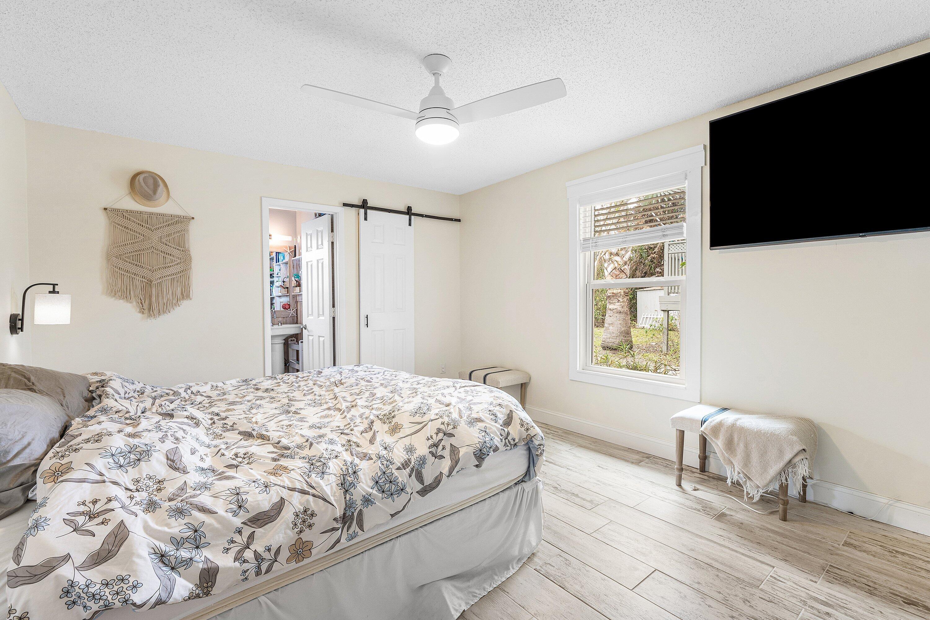 2114 Southeast Midtown Road Port St. Lucie, FL 34952 - Photo 17 of 41 a bedroom with a bed tv and a window