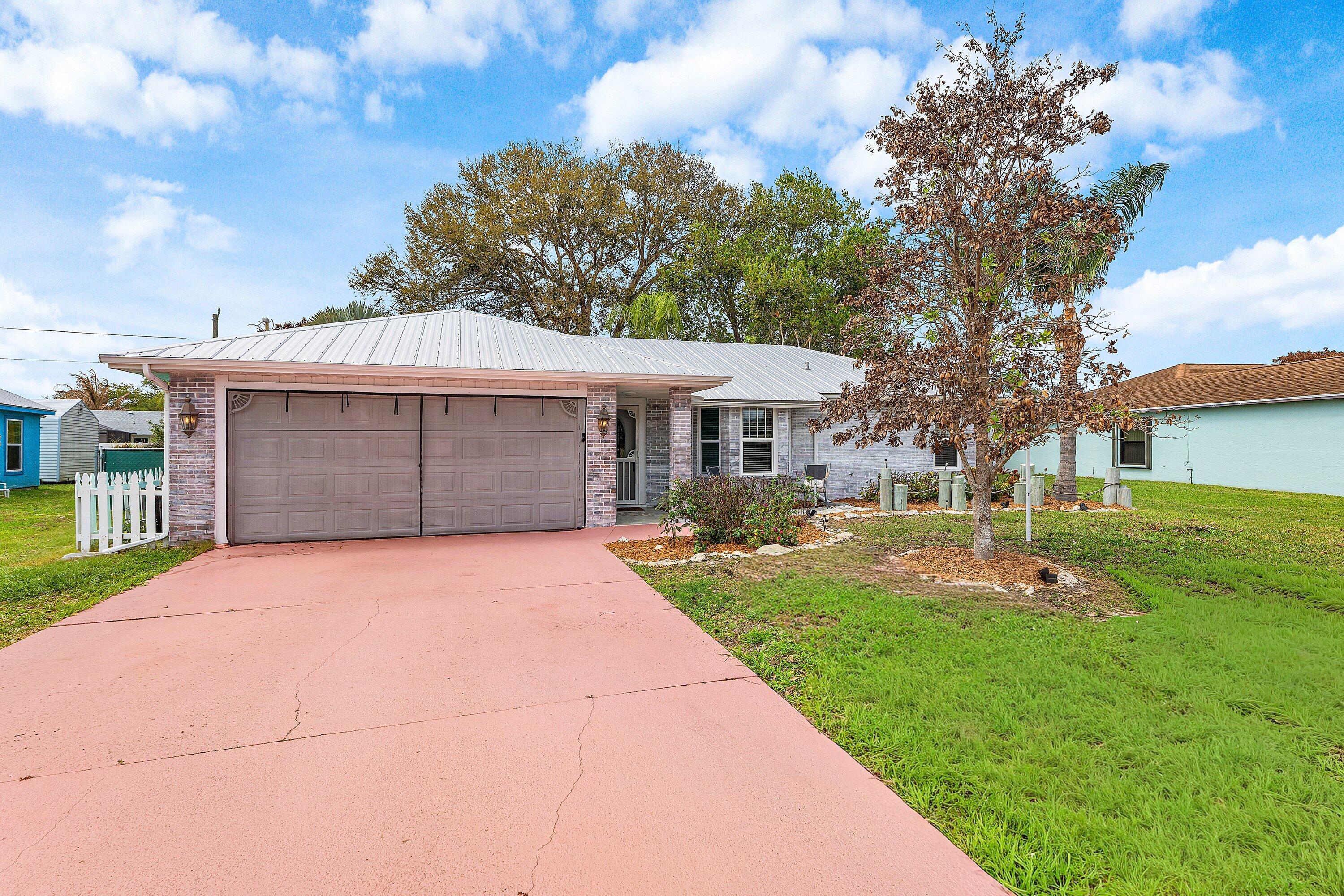 2114 Southeast Midtown Road Port St. Lucie, FL 34952 - Photo 2 of 41 a front view of a house with garden