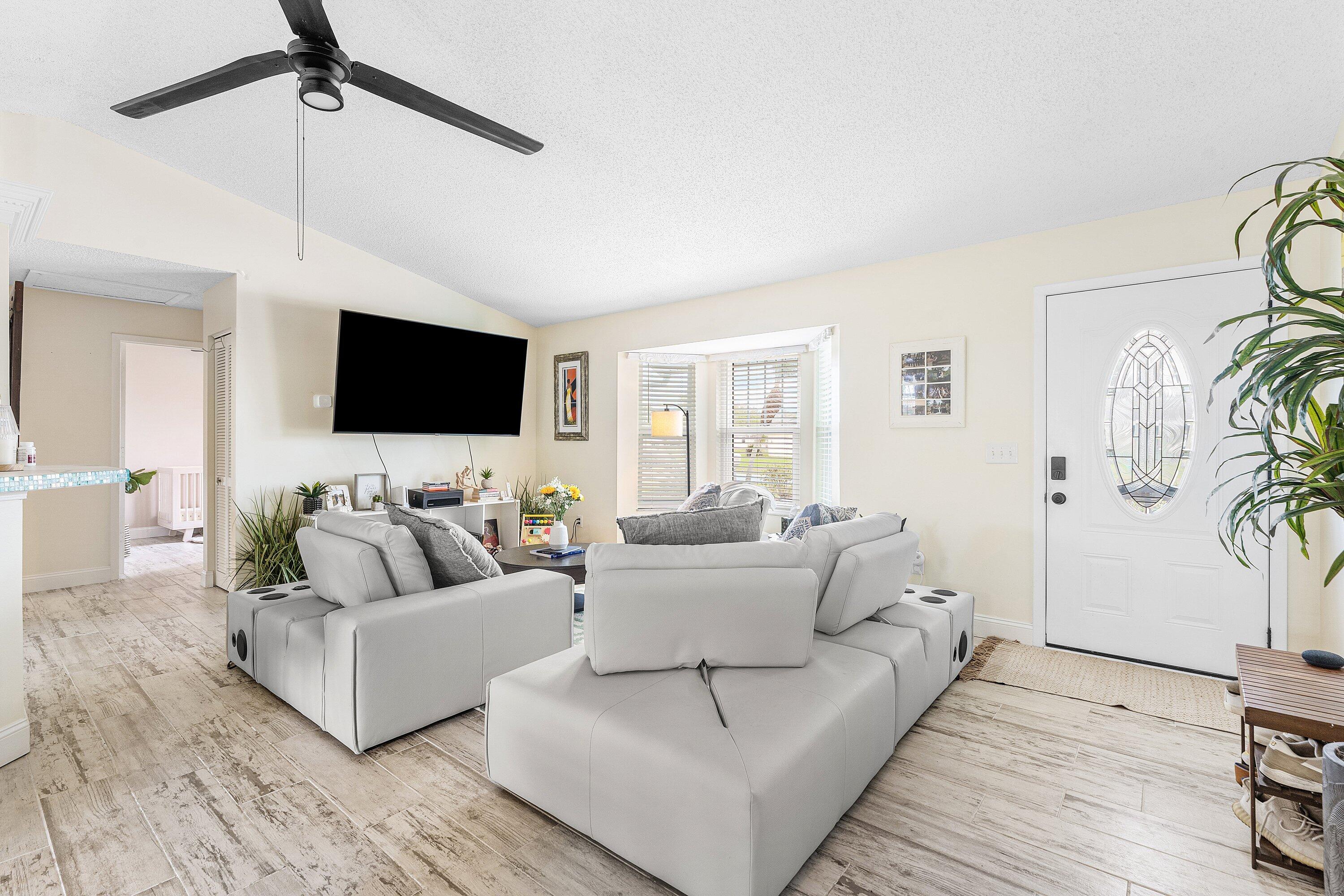 2114 Southeast Midtown Road Port St. Lucie, FL 34952 - Photo 7 of 41 a living room with furniture and a flat screen tv